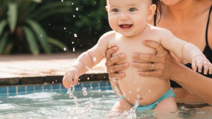 Baby der bader trygt med forælder i pool
