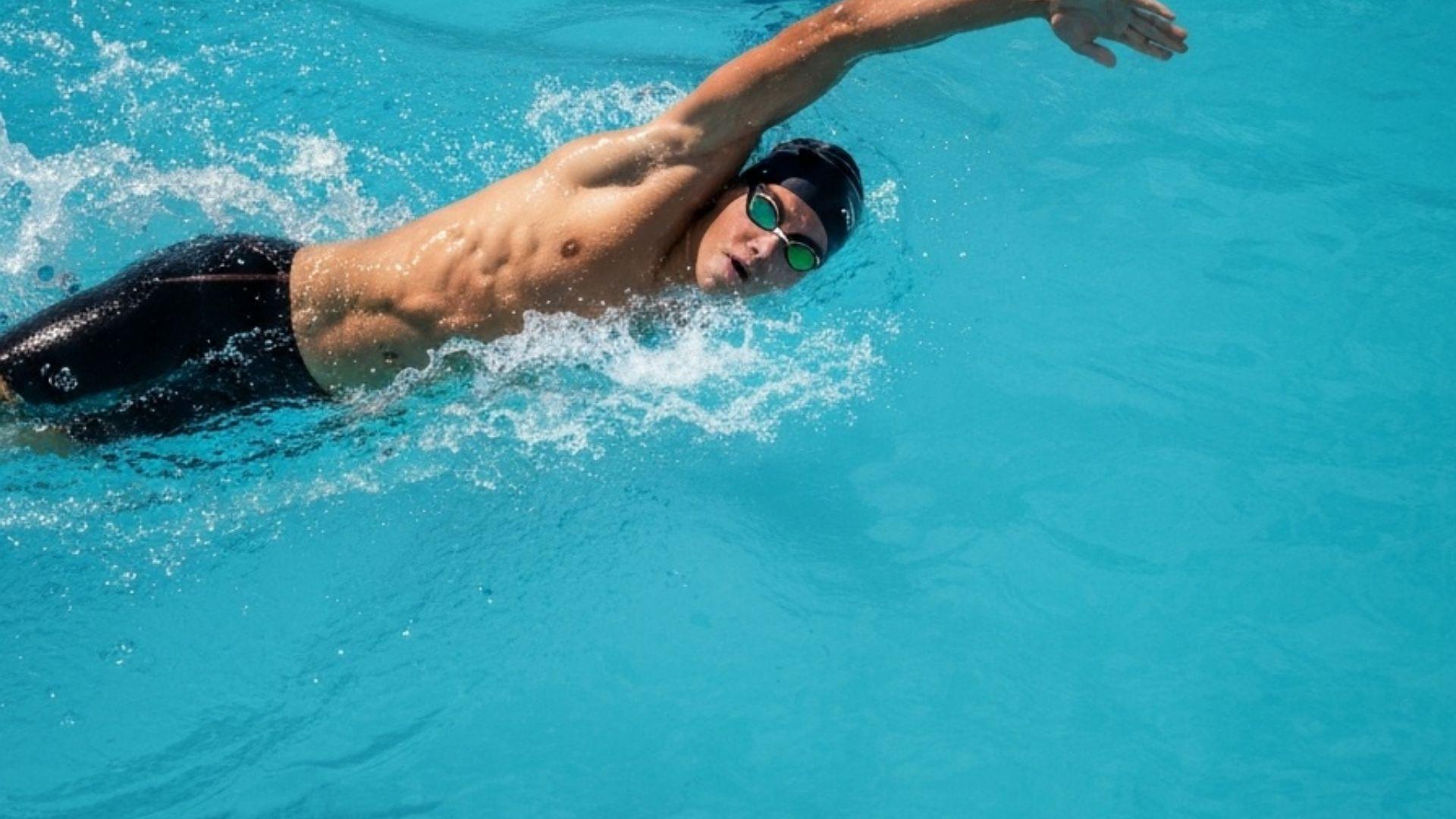 Simmare som utför crawl i poolbana